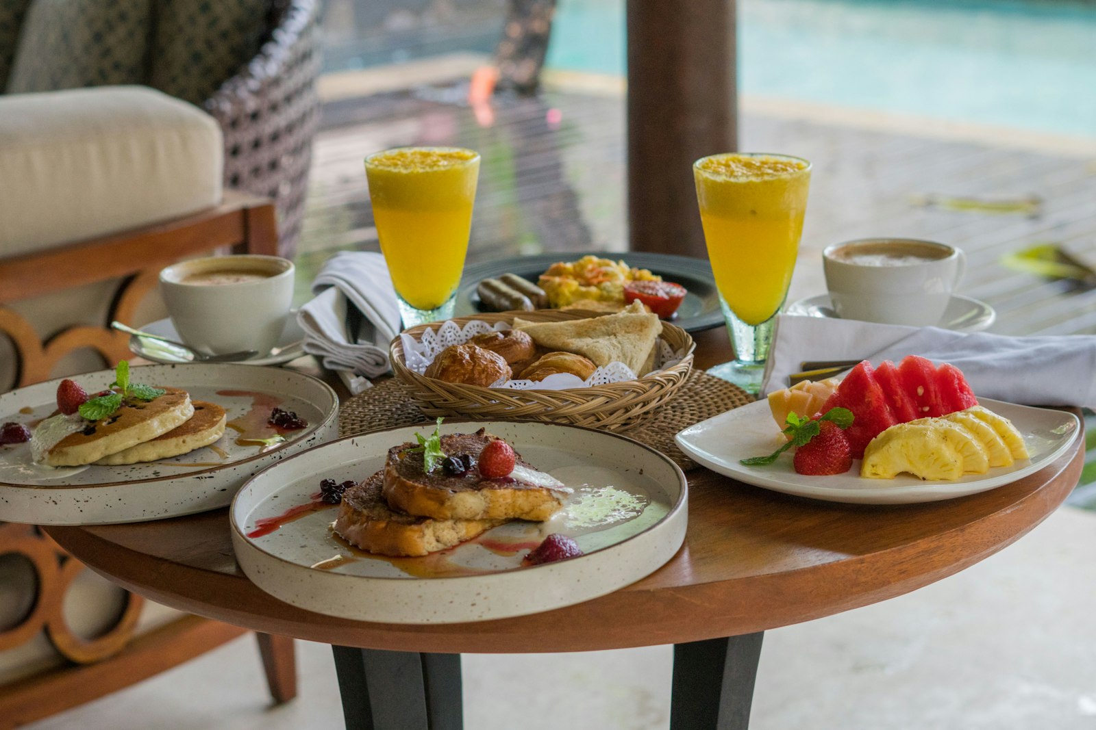 Sarapan dengan buah, roti dan jus di meja kayu