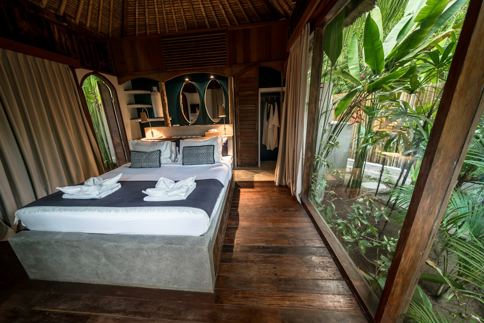 Kamar tidur dengan jendela besar menghadap pepohonan